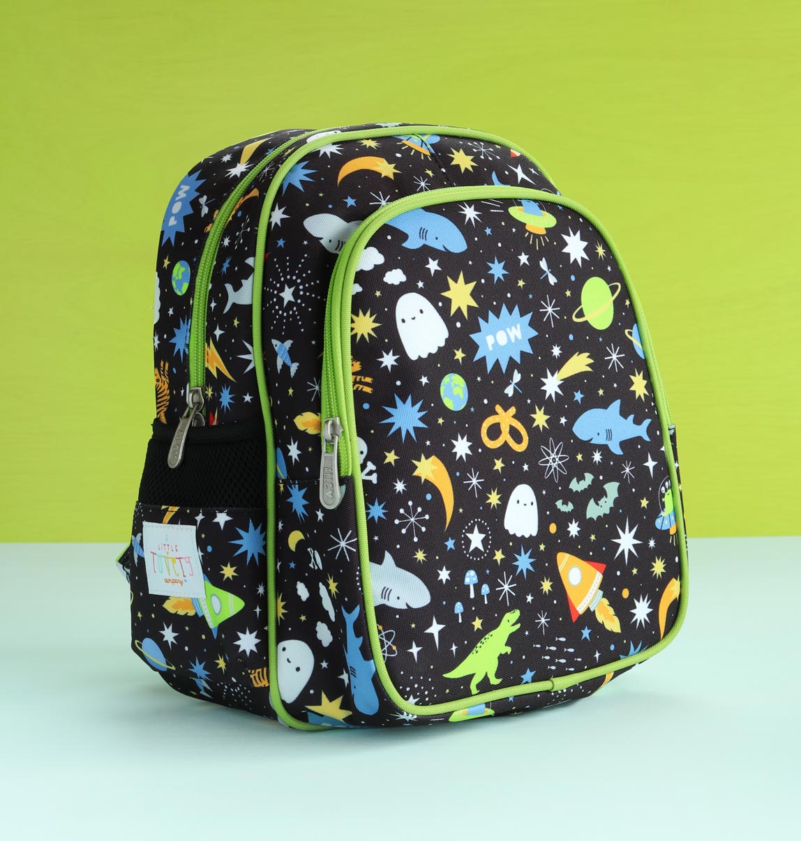 Zijaanzicht van zwarte galaxy rugzak met stoere print, op groene achtergrond