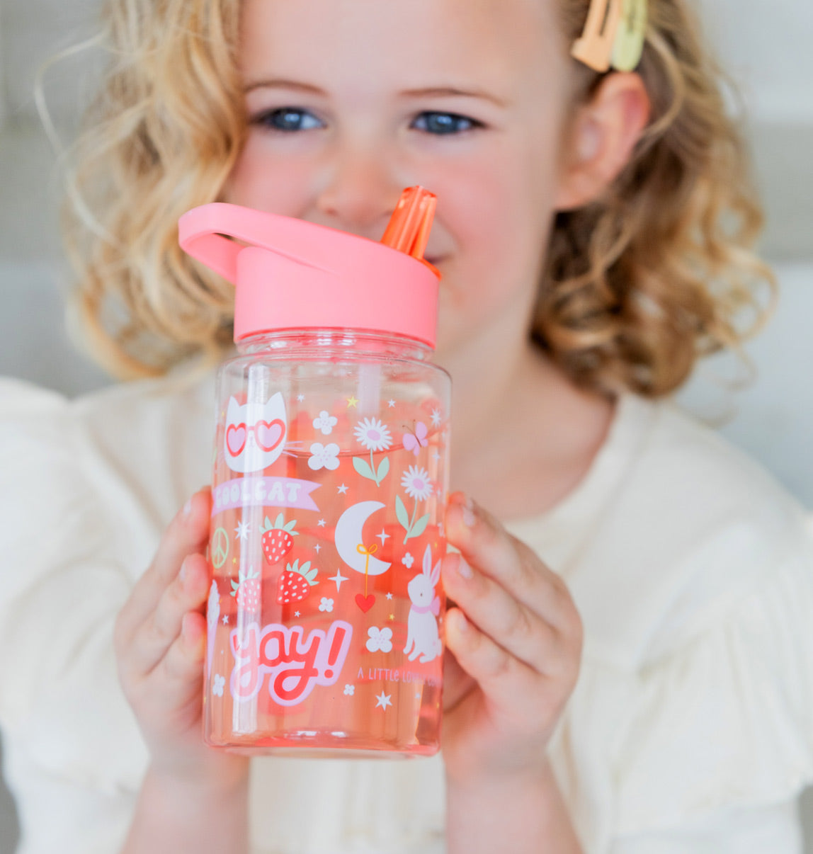 meisje met transparante drinkfles met roze dop en vrolijke print voor kinderen
