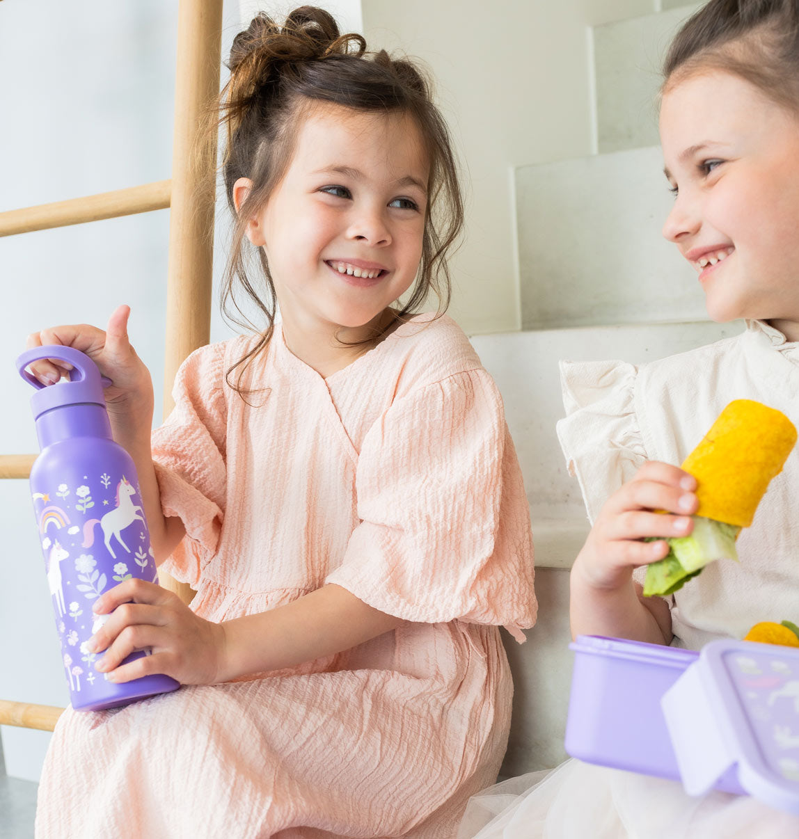 twee meisjes en een paarse drinkfles