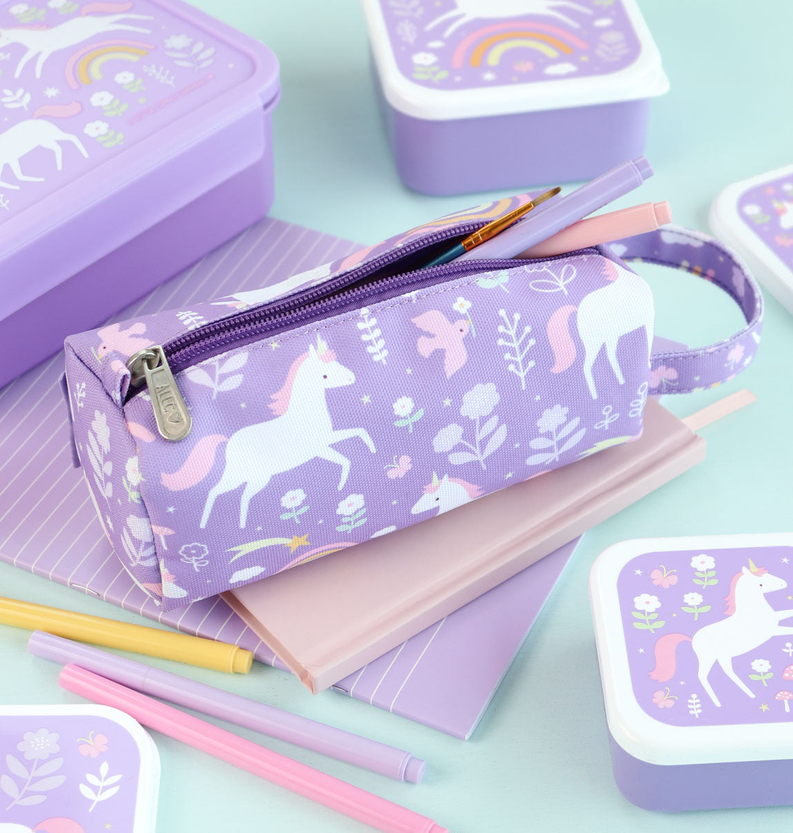 Paarse Unicorn Dreams etui omringt door andere stationary en back to school artikelen