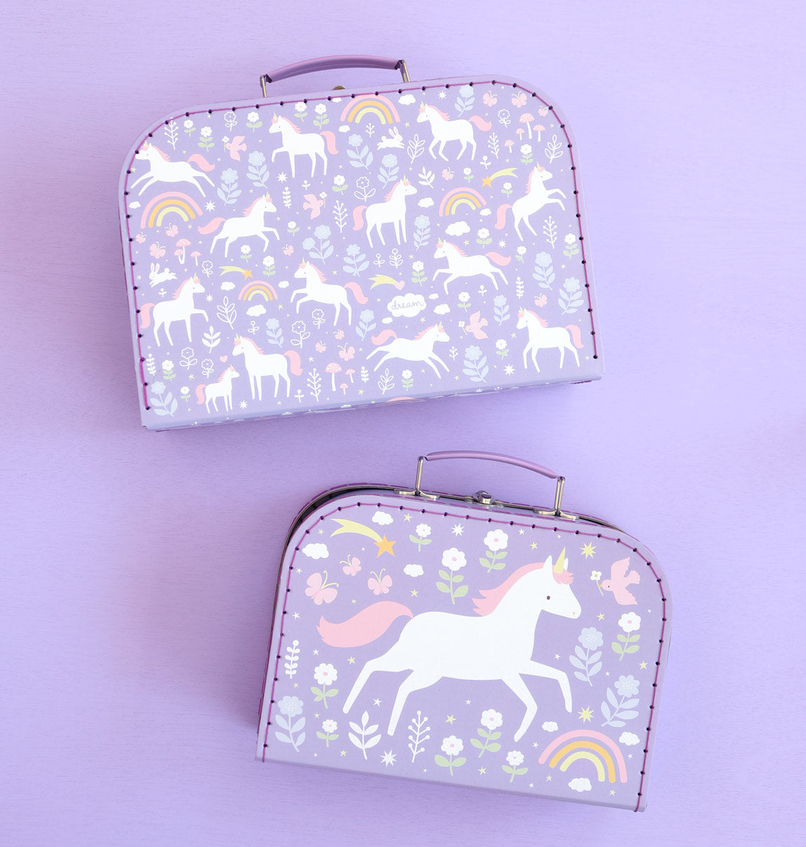 twee paarse kartonnen koffers met fantasierijke print met eenhoorns